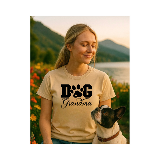Woman wearing a 'Dog Grandma' t-shirt with a dog by her side, set against a scenic background.