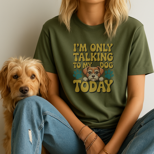 Person wearing a green t-shirt with a dog graphic and text, sitting next to a dog.