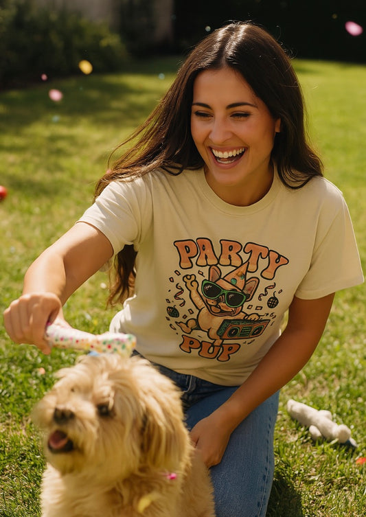Woman in a 'Party Pop' t-shirt with a dog on grass