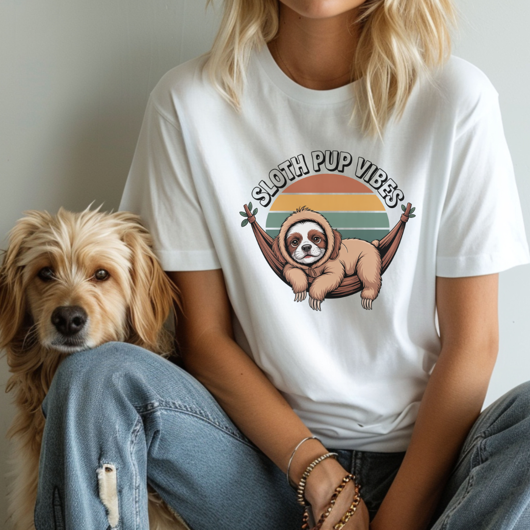 Person wearing a white t-shirt with a sloth graphic and 'Sloth Pup Vibes' text, sitting next to a dog.