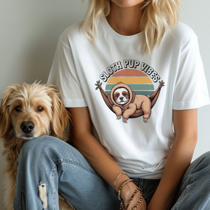 Person wearing a white t-shirt with a sloth graphic and 'Sloth Pup Vibes' text, sitting next to a dog.