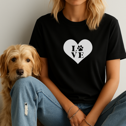 Person wearing a black t-shirt with a heart and paw print design, sitting next to a dog.